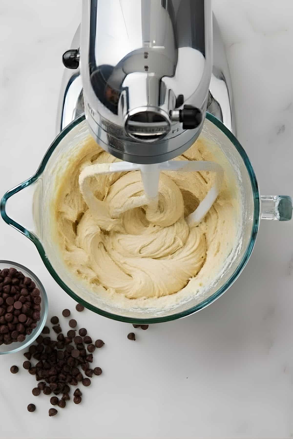 Creamy cookie dough being mixed in a stand mixer.