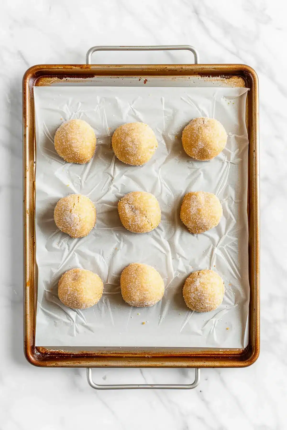 Delicious homemade sugar cookie dough balls on parchment paper, ready for baking, perfect for classic cookie recipes.
