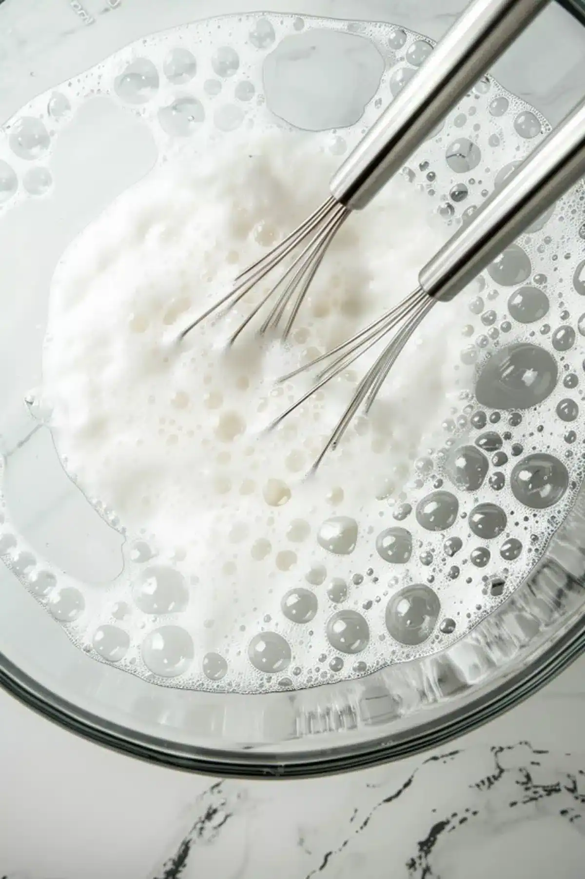 Alt text: Beaters whisking milk or cream in a bowl, ideal for baking and cookie dough preparation.
