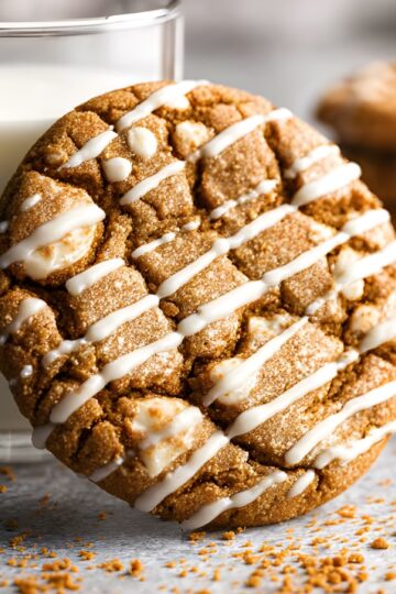 Decorated oatmeal cookie with icing drizzle, golden-brown and crispy texture.